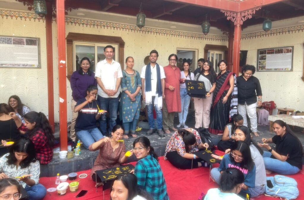 A group of local women artisans in Madhapar village learning the traditional freehand Rogan painting technique from Ashish and Komal Kansara.