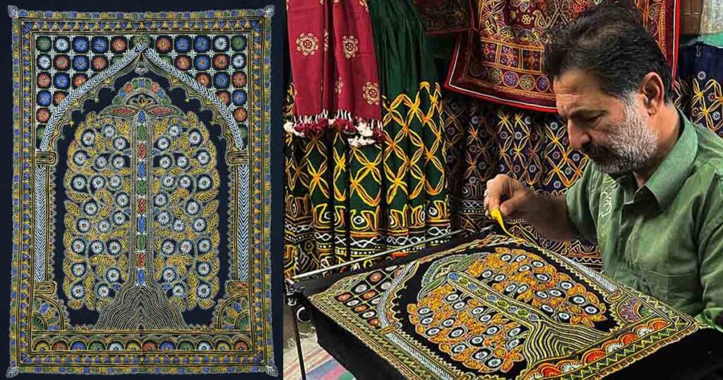 Dr. Ashish Kansara, the world's only Hindu Rogan art master, drawing fine paint threads onto fabric in Madhapar